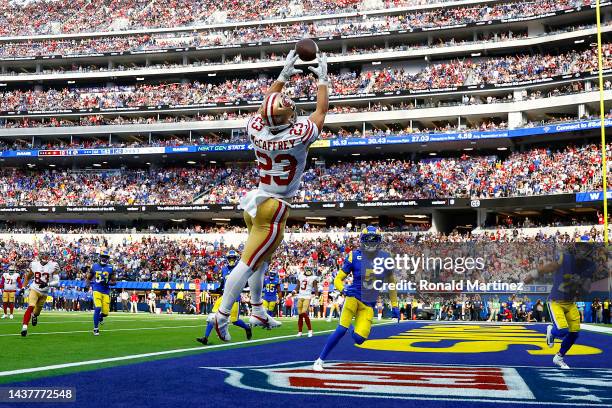 Christian McCaffrey of the San Francisco 49ers catches the ball for a touchdown as Jalen Ramsey and Taylor Rapp of the Los Angeles Rams defend during...