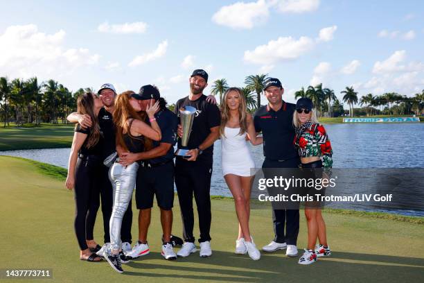 Talor Gooch, Pat Perez, Team Captain Dustin Johnson, and Patrick Reed of 4 Aces GC, with their wives, celebrate with the championship trophy after...