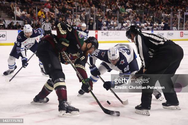 Pierre-Luc Dubois of the Winnipeg Jets and Lawson Crouse of the Arizona Coyotes face off during the third period of the NHL game at Mullett Arena on...