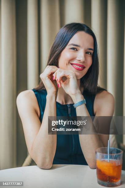 beautiful woman sitting in restaurant in business investment meeting and smiling - bar drink establishment stock pictures, royalty-free photos & images