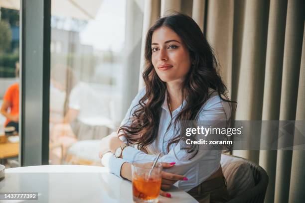 beautiful woman sitting in restaurant and waiting for potential partner in business investment meeting - bar drink establishment stock pictures, royalty-free photos & images