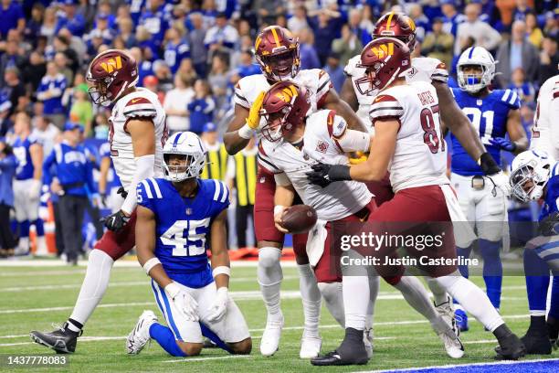 Taylor Heinicke of the Washington Commanders celebrates with teammates after scoring a touchdown in the fourth quarter of a game against the...