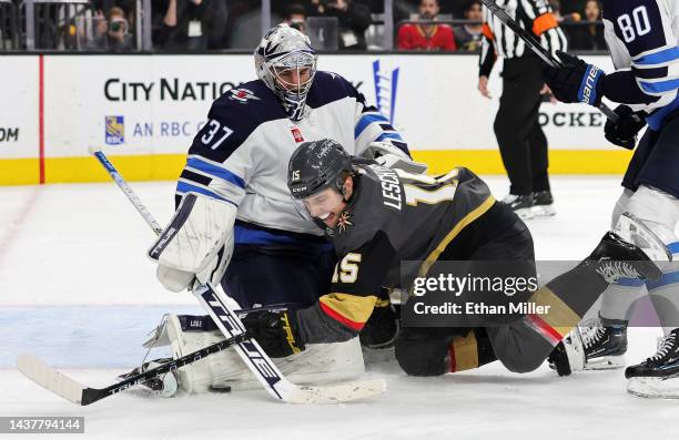 Connor Hellebuyck of the Winnipeg Jets makes a save against Jake Leschyshyn of the Vegas Golden Knights in the second period of their game at...