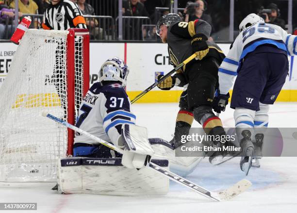 Jack Eichel of the Vegas Golden Knights scores a goal with seven seconds left in overtime against Connor Hellebuyck of the Winnipeg Jets as Mark...