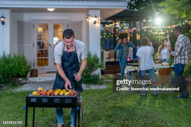 dinner party, barbecue and roast pork at night - backyard grilling stock pictures, royalty-free photos & images