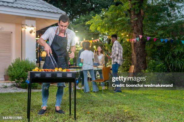 dinner party, barbecue and roast pork at night - backyard grilling stockfoto's en -beelden