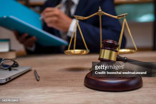 male lawyer working with contract papers and wooden gavel on tabel in courtroom. justice and law ,attorney, court judge, concept. - processo foto e immagini stock