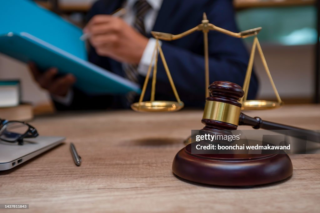 Male lawyer working with contract papers and wooden gavel on tabel in courtroom. justice and law ,attorney, court judge, concept.