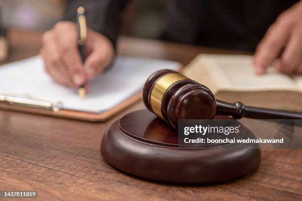 male lawyer working with contract papers and wooden gavel on tabel in courtroom. justice and law ,attorney, court judge, concept. - urteil gerichtsverfahren stock-fotos und bilder