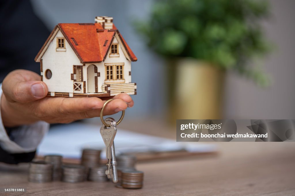 A closeup shot of a person thinking of buying or selling a house