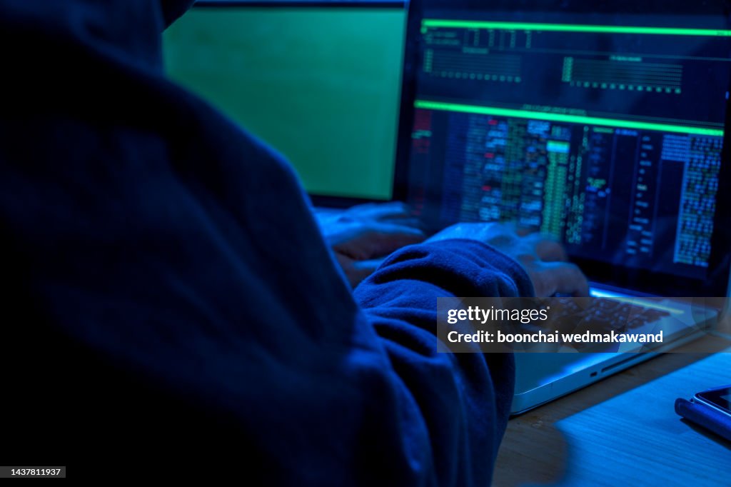 Wanted hackers coding virus ransomware using laptops and computers. Cyber attack, system breaking and malware concept.