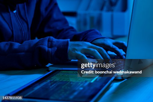 Wanted hackers coding virus ransomware using laptops and computers. Cyber attack, system breaking and malware concept. Wanted hackers coding virus ransomware using laptops and computers. Cyber attack, system breaking and malware concept.