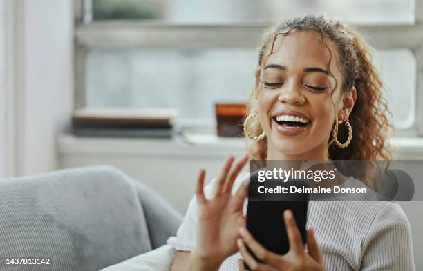 social media, meme and woman laughing with her phone in hand, sitting at home on sofa. relax, weekend and happy black girl looking at funny video online, using internet and smiling at smartphone - meme text stock pictures, royalty-free photos & images