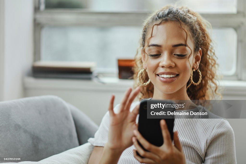 Black woman with smartphone on a sofa for networking online, mobile app or relax chat with home wifi. Young person on couch using phone for internet, social media post or email communication update