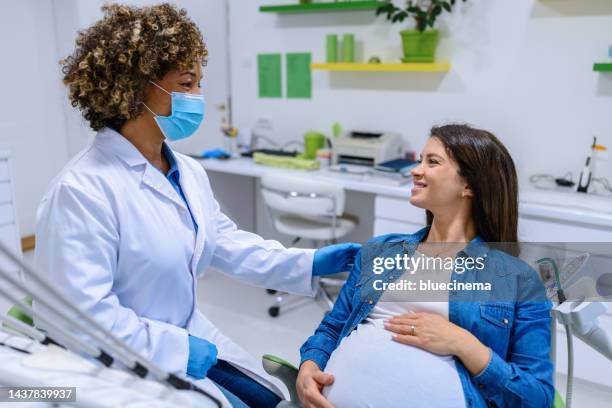 pregnant woman visiting a dentist - dental patient stock pictures, royalty-free photos & images