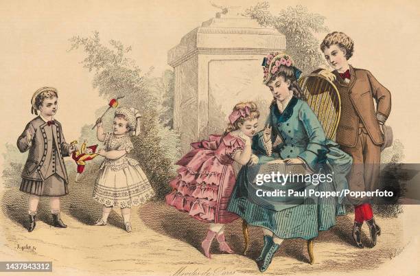 Colour plate from Journal Des Demoiselles showing a group of girls and boys playing outside, an older girl wears a blue double breasted coat with...