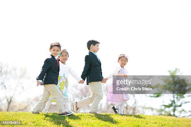 kids walking hand in hand - easter sunday stock pictures, royalty-free photos & images