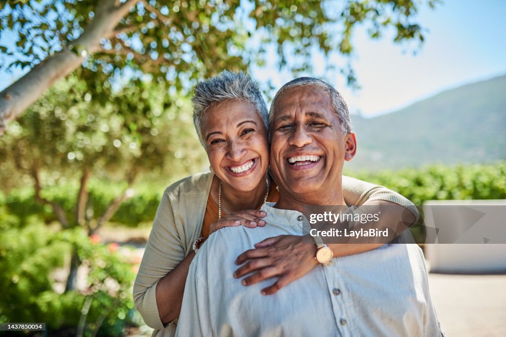Senior couple, smile and outdoor in nature park showing love, care and happy on a retirement holiday on summer day. Portrait of elderly man and woman together for fresh air and tree view on vacation