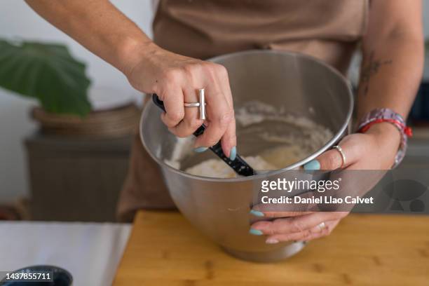 close up view of a confectioner mixing ingredients while preparing a cake. - making a cake stock pictures, royalty-free photos & images