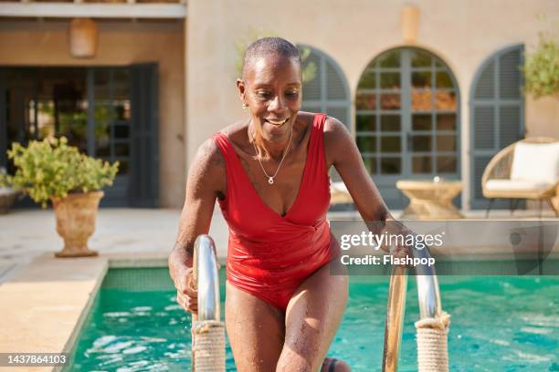 woman climbing out of a  swimming pool - mature women swimming stock pictures, royalty-free photos & images