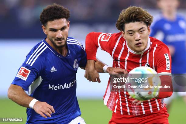 Ritsu Doan of SC Freiburg battles for the ball with Kerim Calhanoglu of Schalke during the Bundesliga match between FC Schalke 04 and Sport-Club...