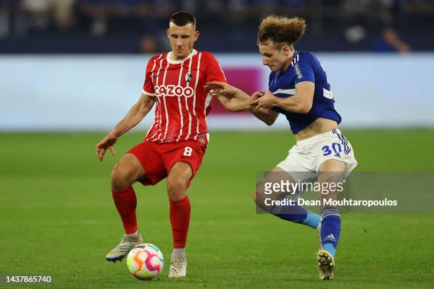 Maximilian Eggestein of SC Freiburg battles for the ball with Alex Kral of Schalke during the Bundesliga match between FC Schalke 04 and Sport-Club...