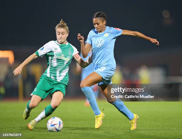 Sveindis Jane Jonsdottir of VfL Wolfsburg is challenged by Michelle Ulbrich of Werder Bremen during the FLYERALARM Frauen Bundesliga match between...