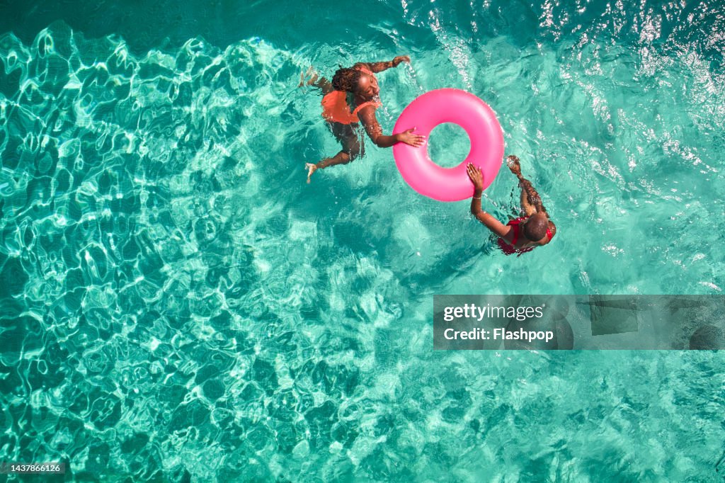 Aerial view point of mother and daughter swimming together.