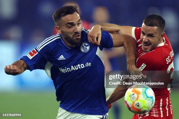 Kerim Calhanoglu of Schalke battles for the ball with Christian Gunter of SC Freiburg during the Bundesliga match between FC Schalke 04 and...