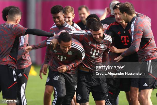 Lucas Hernandez of FC Bayern München reacts with his team mate Leroy Sane during a training session at Saebener Strasse training ground ahead of...