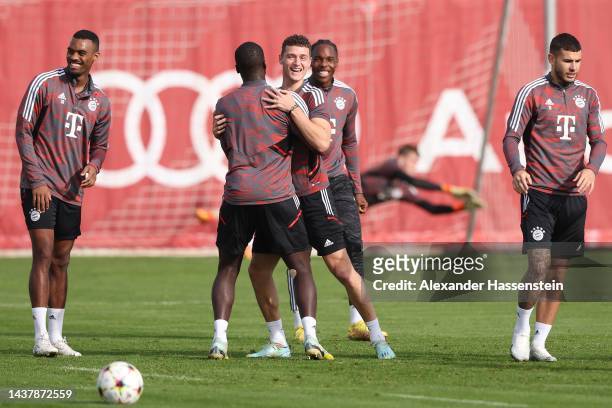 Benjamin Pavard of FC Bayern München reacts with his team mate Leroy Sane during a training session at Saebener Strasse training ground ahead of...