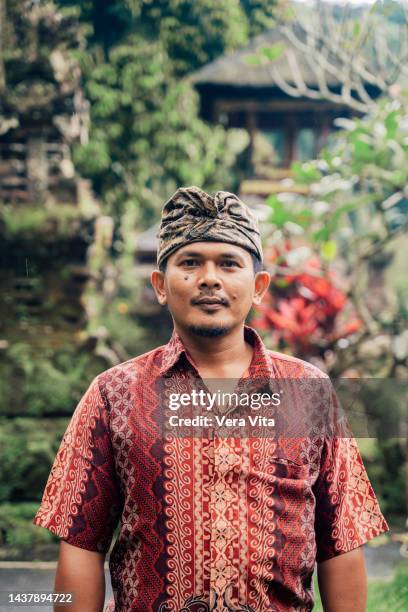 front view of exotic religious man standing on temple in ubud, bali. - balinese culture stock-fotos und bilder