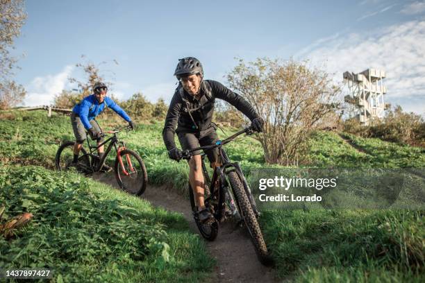 zwei schwarze mountainbiker auf dem trail - bicycle trail outdoor sports stock-fotos und bilder