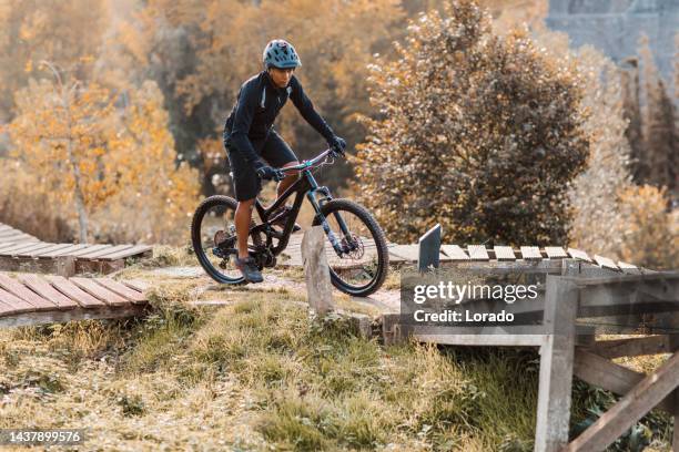 an adventurous black mountain biker alone on the trail - bicycle trail outdoor sports stockfoto's en -beelden