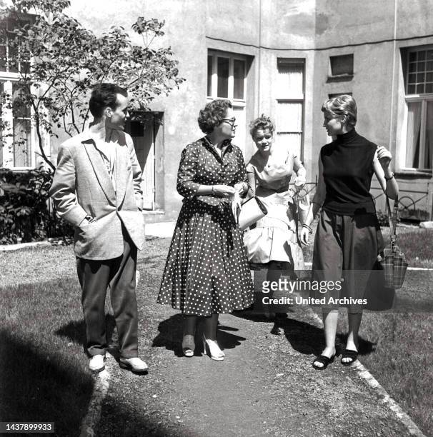 Original-Bildunterschrift: Und dann ist Magda Schneider mit Tochter Romy gekommen und im kleinen Garten des Hotels vertritt sich vor dem Essen...