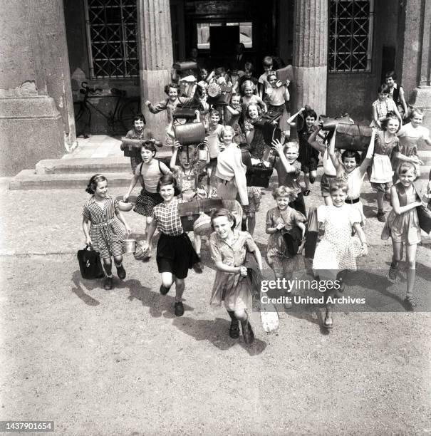 Hinein in die großen Ferien - Kinder stürmen am letzten Schultag aus dem Schulgebäude ins Freie, in die Sommerferien, Berlin, Deutschland 1955.