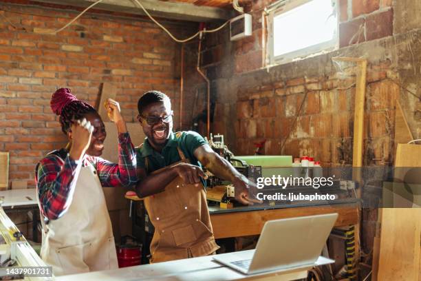 colleagues celebrate a success with enthusiastic facial expressions looking at the notebook screen - unusual imagens e fotografias de stock