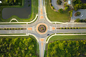 Aerial view of road roundabout intersection with moving cars traffic. Rural circular transportation crossroads