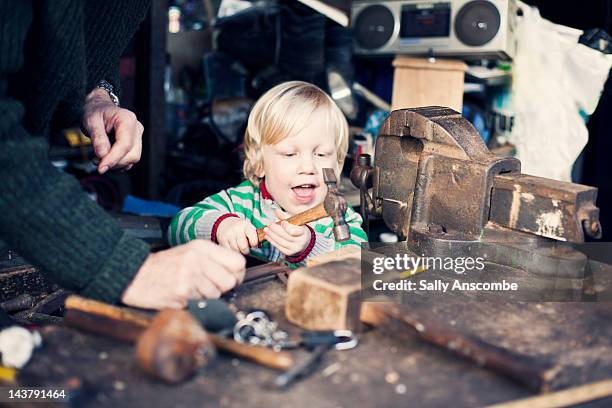 Child helping his grandpa in shed