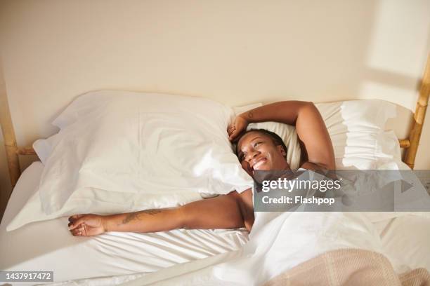 portrait of woman waking up in bed. - morning bed stretch fotografías e imágenes de stock