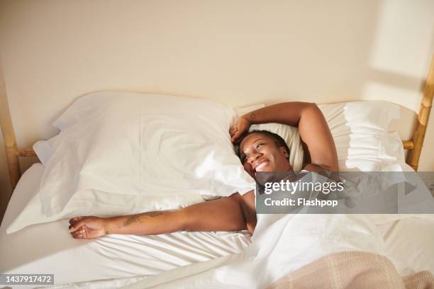 portrait of woman waking up in bed. - 起床 個照片及圖片檔