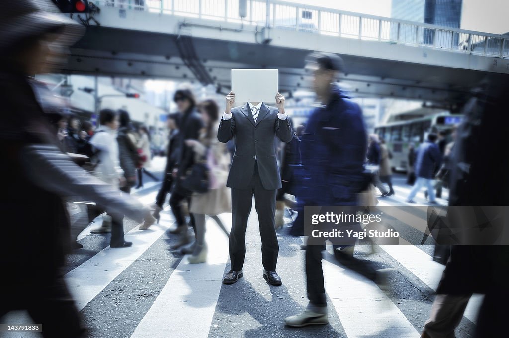 Businessman with a white board in a crosswalk