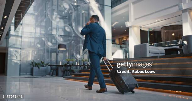 uomo d'affari, telefonata e bagagli per viaggi, aeroporto e viaggio di lavoro per il networking con contatto. lavoratore aziendale parla con lo smartphone mobile 5g e cammina verso il volo, l'immigrazione o il terminal - g man foto e immagini stock