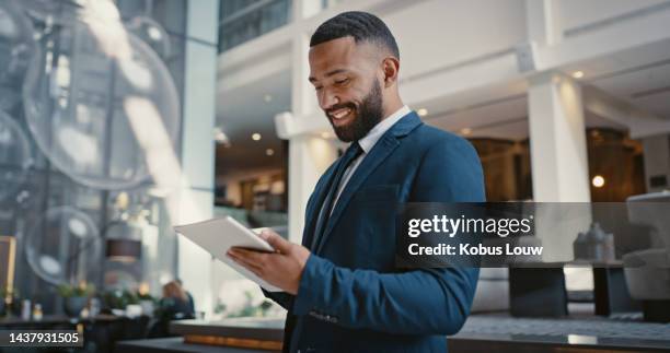 businessman, digital tablet or strategy planning in hotel conference lobby or airport travel lounge. happy smile, corporate worker or technology app to budget company finance or schedule target goals - african american business man stockfoto's en -beelden