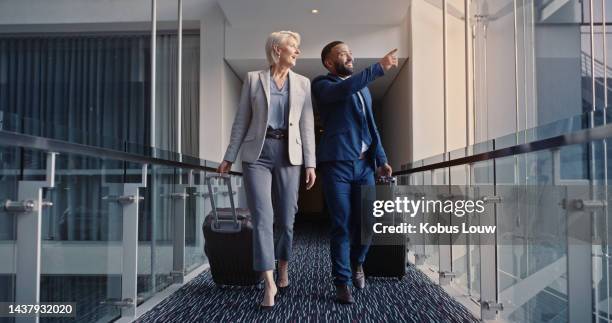 business people, travel for work and at hotel, luggage and business trip for conference or company retreat. woman, man and walking with suitcase, professional and working event for staff. - conference hotel stock pictures, royalty-free photos & images