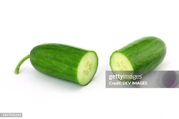 cucumber halves isolated on white background - gurke stock-fotos und bilder