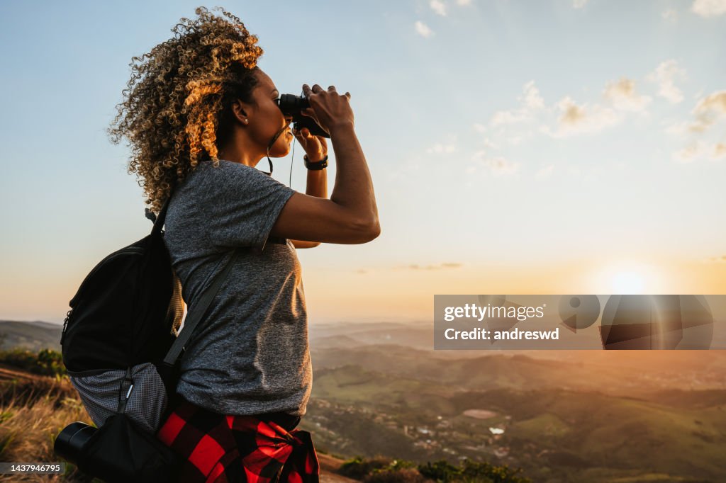 Backpacker woman using binoculars