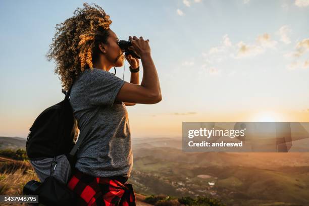 backpacker woman using binoculars - woman adventure stock pictures, royalty-free photos & images