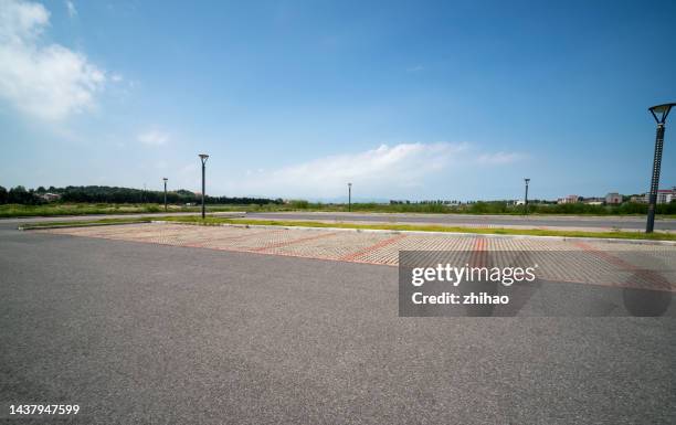 low angle view of empty parking lot on sunny day - parkplatz leer stock-fotos und bilder