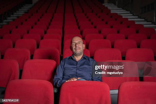 one confidence director business man in an empty theater posing at camera - director chair bildbanksfoton och bilder